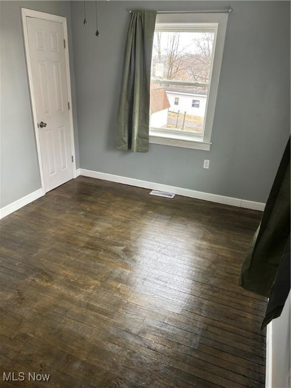 spare room with dark wood-type flooring