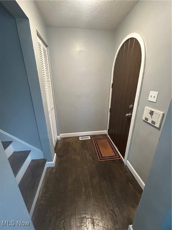 interior space featuring a textured ceiling and dark hardwood / wood-style flooring