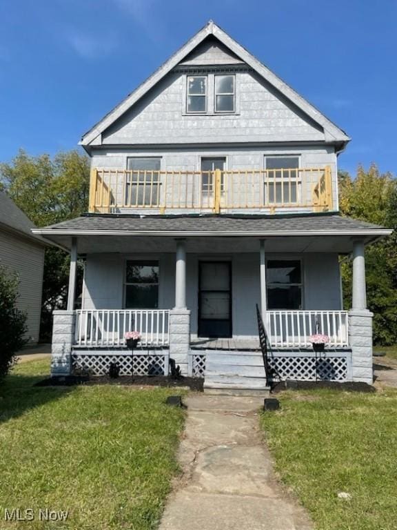 view of front of property with a porch, a balcony, and a front lawn