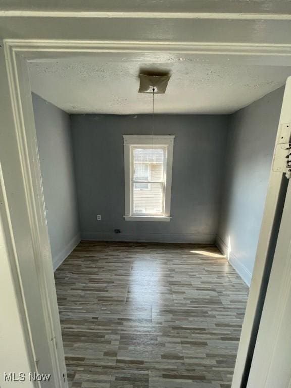 unfurnished dining area with a textured ceiling and light wood-type flooring