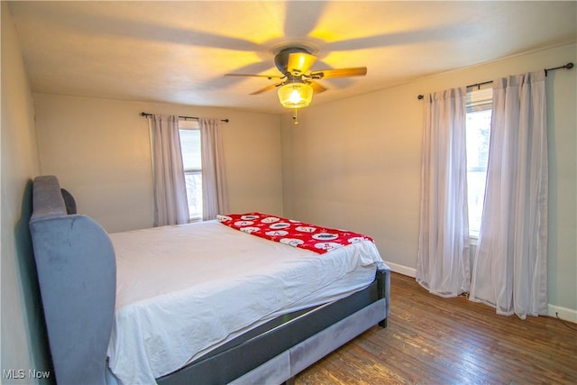 bedroom featuring multiple windows, hardwood / wood-style flooring, and ceiling fan