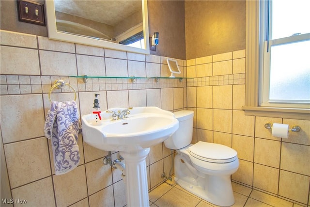 bathroom with tile patterned flooring, plenty of natural light, tile walls, and toilet