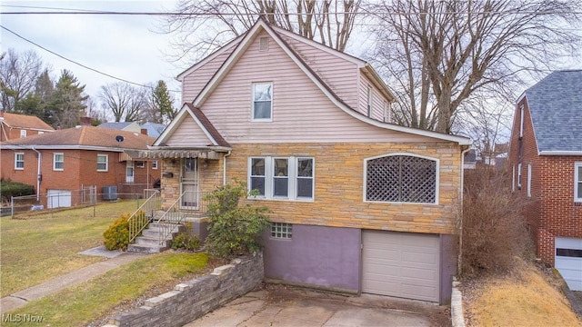 view of front facade featuring a garage, a front yard, and central air condition unit