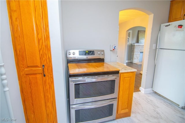 kitchen with range with two ovens and white fridge