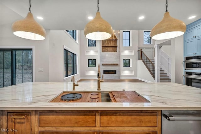 kitchen with a wealth of natural light, pendant lighting, and a fireplace