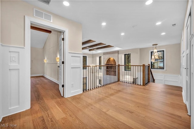 hall featuring beam ceiling and light hardwood / wood-style floors