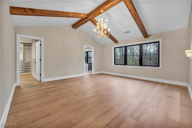 unfurnished living room with lofted ceiling with beams, an inviting chandelier, and light hardwood / wood-style floors