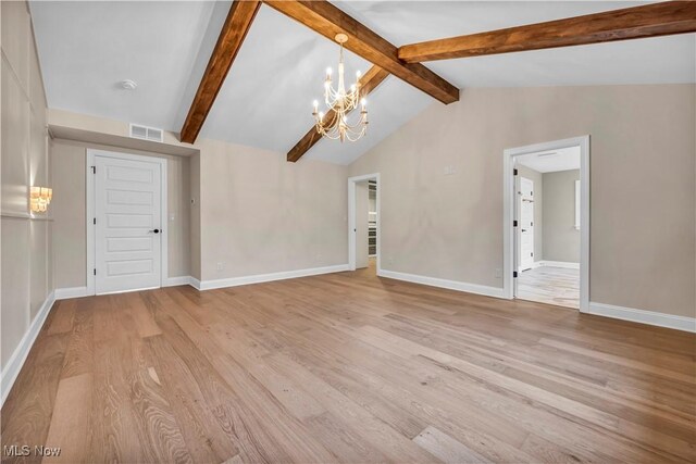 unfurnished living room with lofted ceiling with beams, light hardwood / wood-style floors, and a notable chandelier