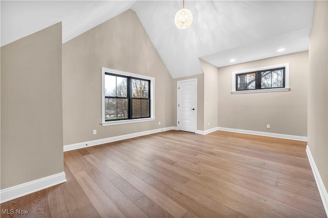 interior space with an inviting chandelier, high vaulted ceiling, and light wood-type flooring