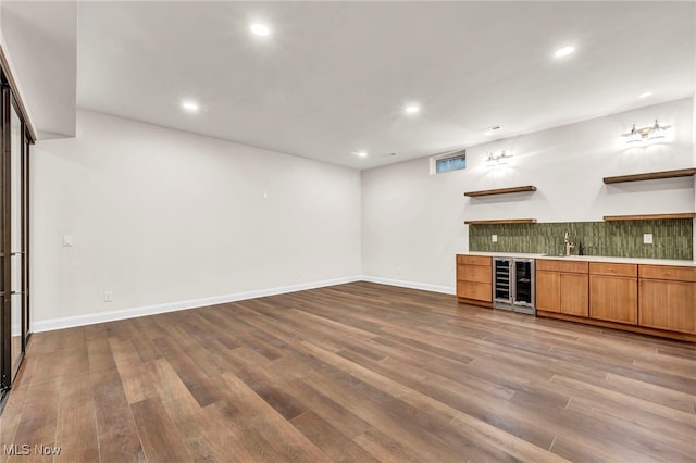 bar with tasteful backsplash, beverage cooler, and dark hardwood / wood-style flooring