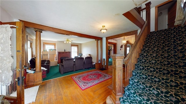 living room with hardwood / wood-style flooring, ceiling fan, and ornate columns