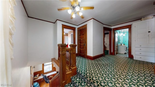 hall with ornamental molding and carpet flooring