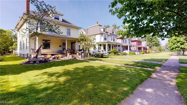 victorian house with a front yard and a porch