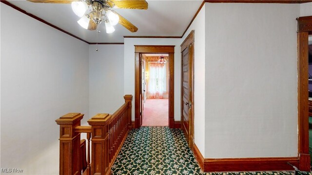 hall with ornamental molding and carpet