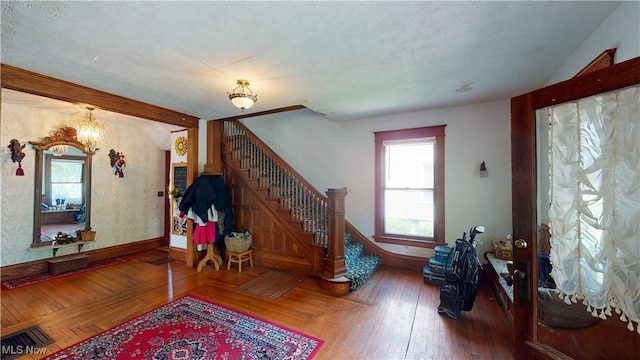 interior space with an inviting chandelier, hardwood / wood-style floors, and a textured ceiling