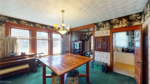 dining space with a chandelier and dark carpet