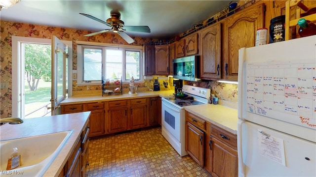 kitchen featuring ceiling fan, white appliances, and sink