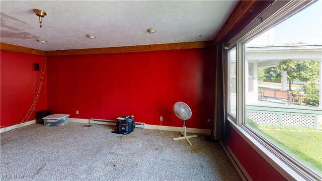 carpeted spare room featuring baseboard heating