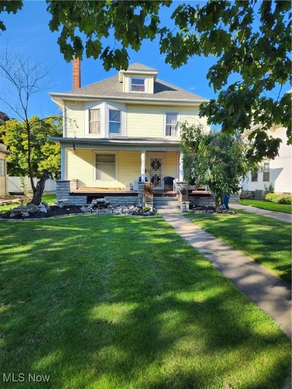 view of front of property with covered porch and a front lawn