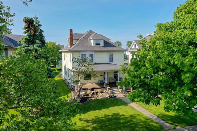 back of property featuring a porch and a yard