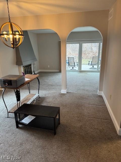 carpeted living room featuring a chandelier