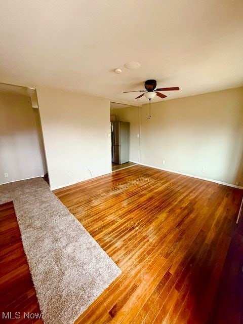 empty room with hardwood / wood-style flooring and ceiling fan