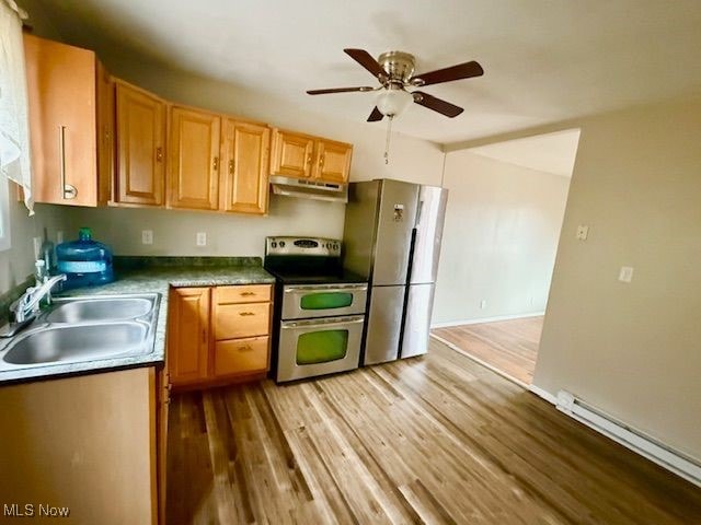 kitchen with sink, ceiling fan, baseboard heating, appliances with stainless steel finishes, and light hardwood / wood-style floors