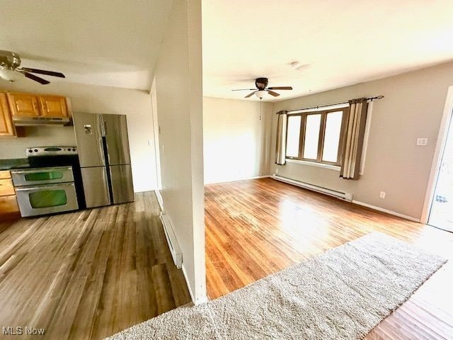 kitchen with stainless steel appliances, ceiling fan, baseboard heating, and light hardwood / wood-style floors