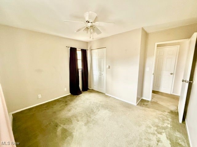 unfurnished bedroom featuring light colored carpet and ceiling fan