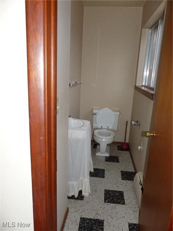 bathroom featuring a baseboard radiator and toilet