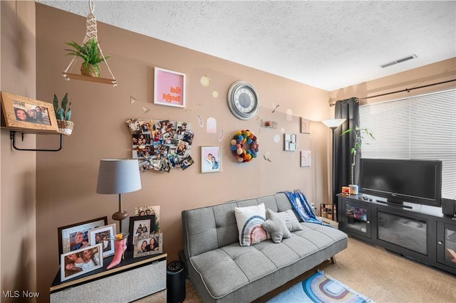 carpeted living room featuring a textured ceiling