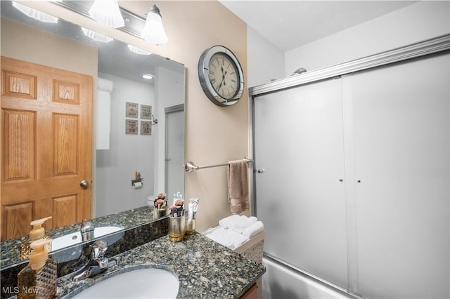 bathroom featuring vanity and enclosed tub / shower combo