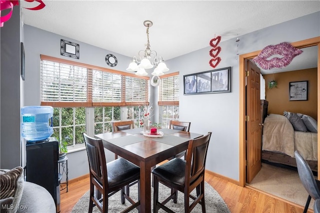 dining area featuring a notable chandelier and light hardwood / wood-style floors