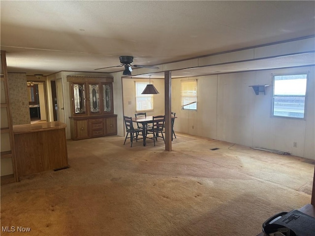 dining space with ceiling fan and carpet flooring