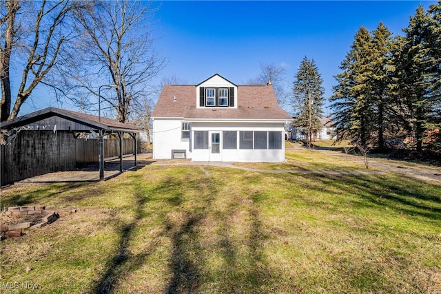 rear view of property featuring a carport, a yard, and a sunroom