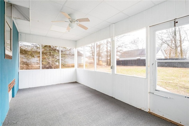 unfurnished sunroom featuring ceiling fan and a drop ceiling