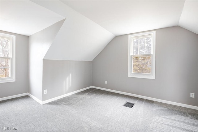 bonus room with carpet flooring and vaulted ceiling