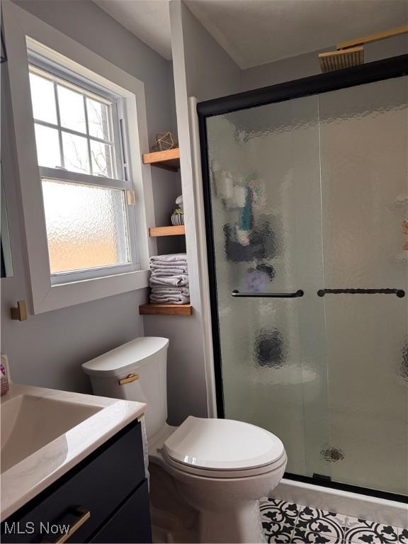 bathroom with vanity, a shower with shower door, and toilet