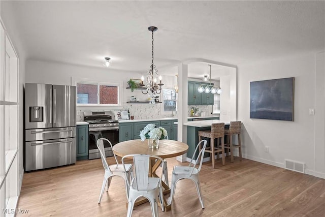 dining room featuring a notable chandelier and light wood-type flooring