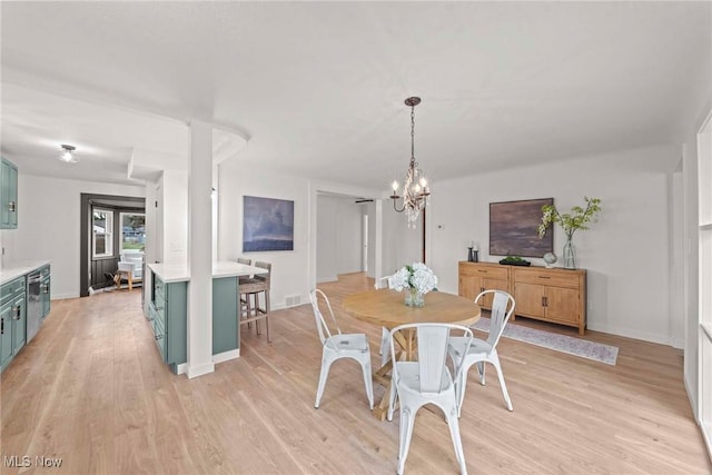 dining area with a chandelier and light wood-type flooring