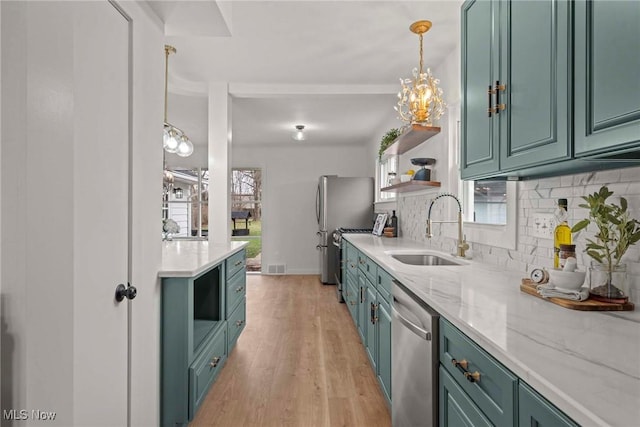 kitchen with sink, appliances with stainless steel finishes, tasteful backsplash, light stone counters, and light wood-type flooring