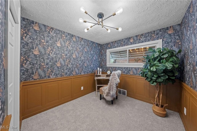 living area featuring carpet flooring, a textured ceiling, and a notable chandelier