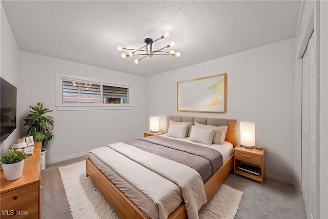 carpeted bedroom featuring an inviting chandelier and a closet