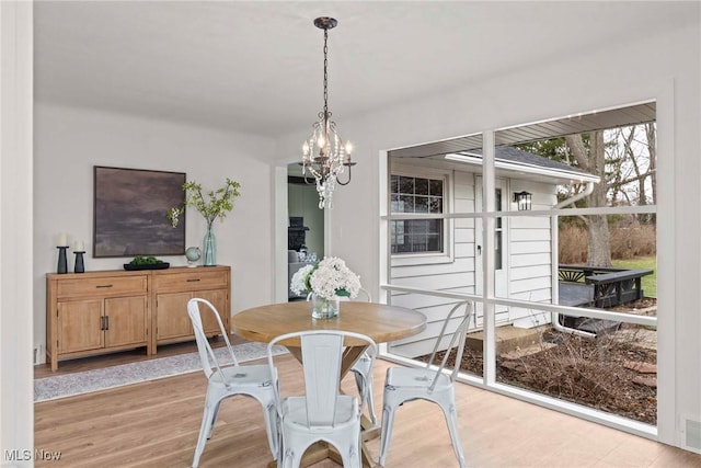 dining area with a notable chandelier and light hardwood / wood-style floors