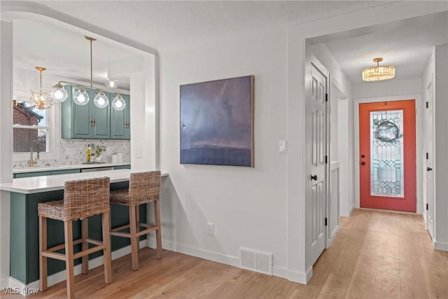 interior space with a notable chandelier, sink, and light wood-type flooring