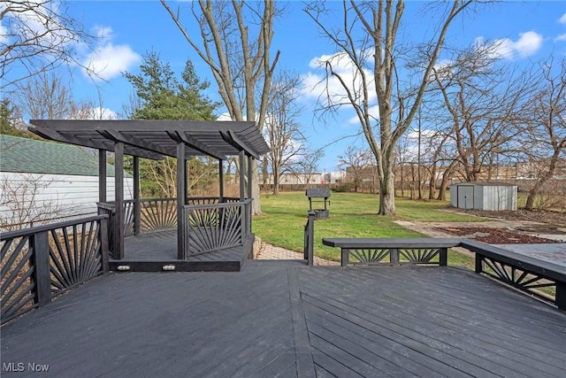 wooden deck with a storage shed and a lawn