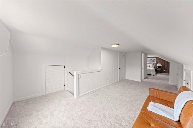 bonus room featuring vaulted ceiling and light colored carpet