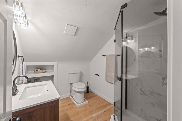 bathroom featuring lofted ceiling, a shower with door, hardwood / wood-style floors, vanity, and toilet