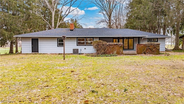 back of house with a yard and central AC