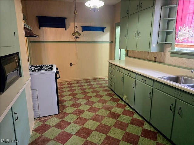 kitchen featuring sink, green cabinets, and range with gas stovetop